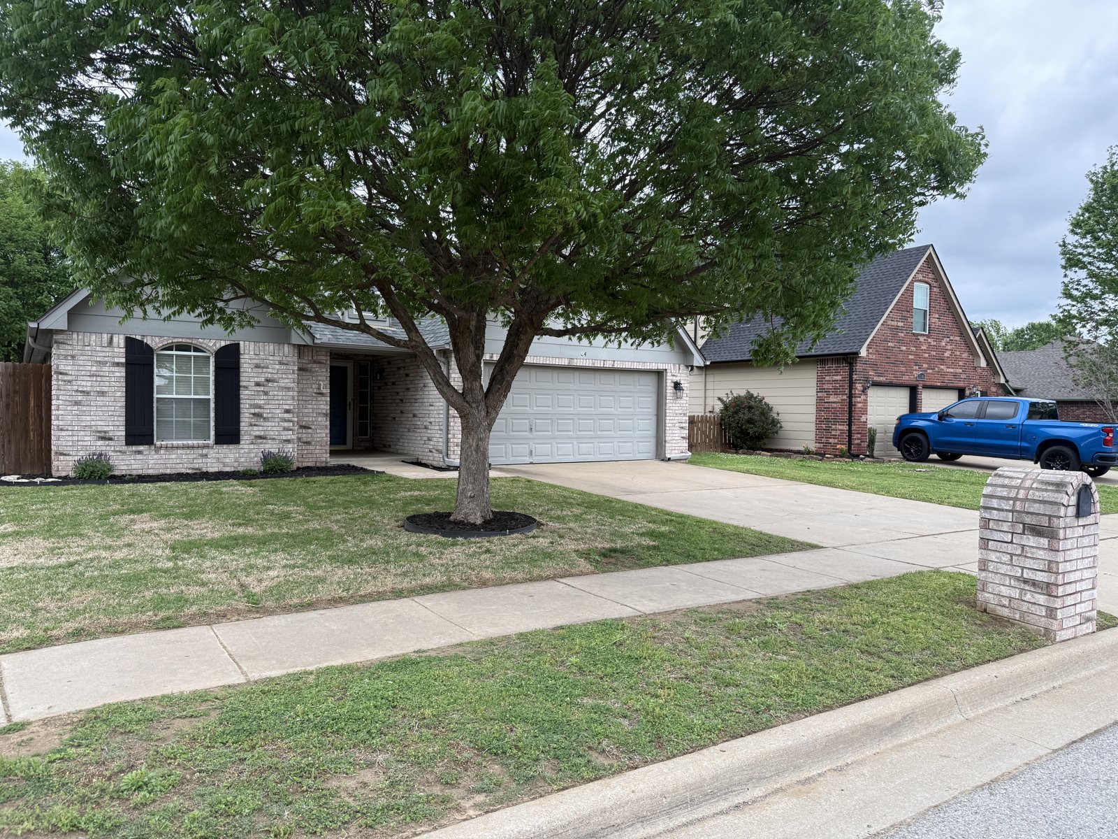 A freshly mowed EllCo lawn and tidy brick home in Tulsa